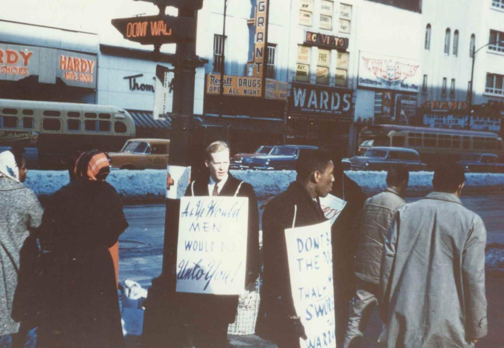 white man carrying sign with black men carrying signs